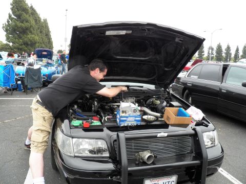 2003 Ford Crown Victoria - Engine work on a black sedan showing an intercooler mounted behind the front grille guard.