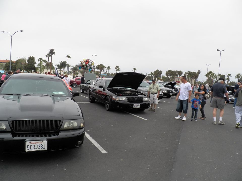 Black Mercury sedan with hood scoop, plate 5CRJ381, families browsing car show