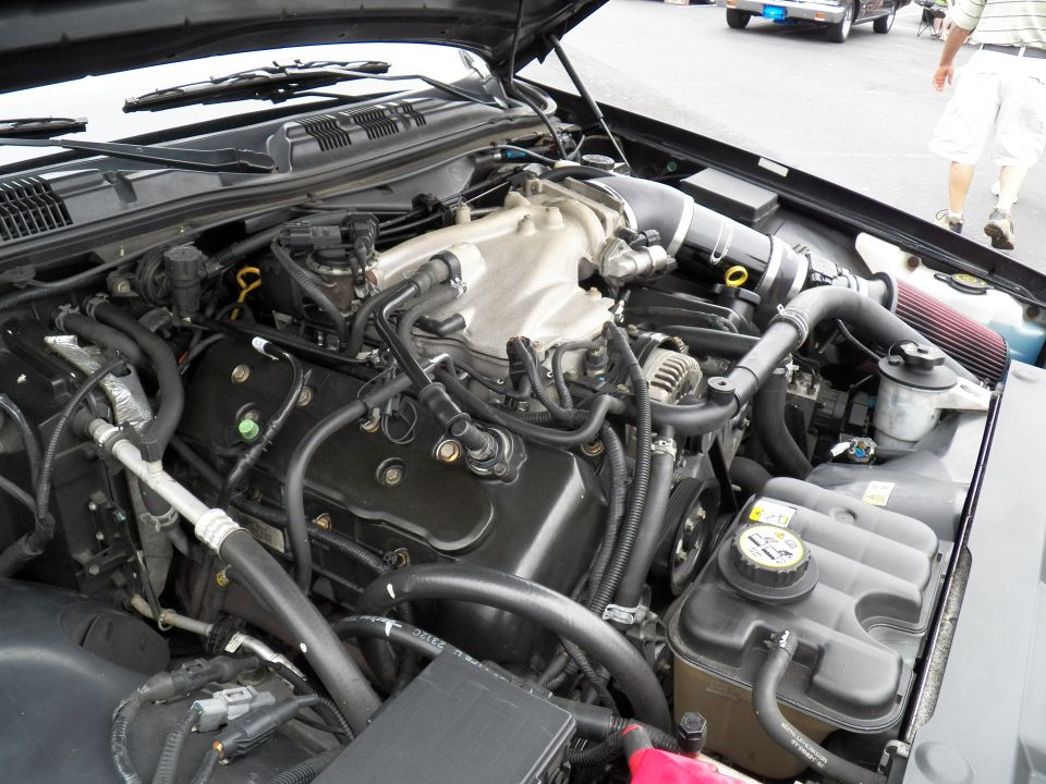 V8 engine bay with intake manifold, coolant reservoir and cone filter in sedan