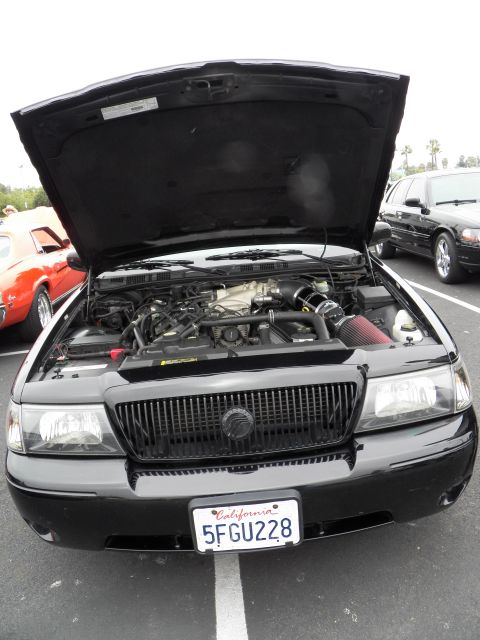 2003 Ford Crown Victoria - Front view of a black Mercury sedan, hood raised to expose the engine, parked in a show lot