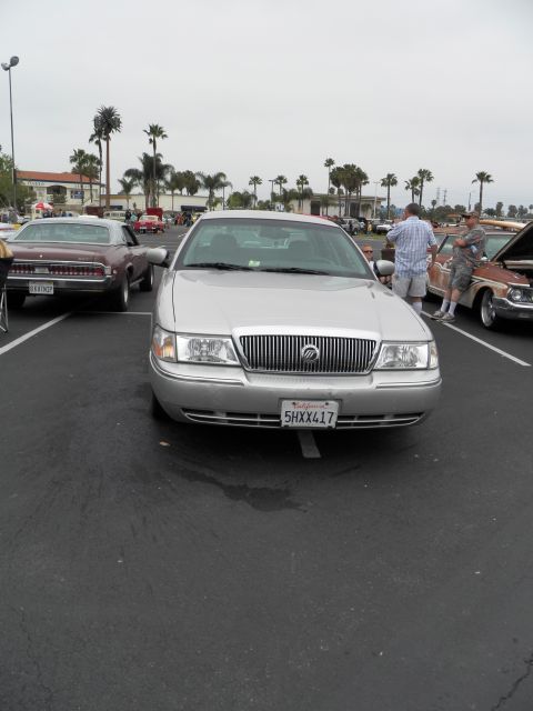 2003 Ford Crown Victoria - Front of a silver Mercury Grand Marquis showing its chrome waterfall grille at a car meet