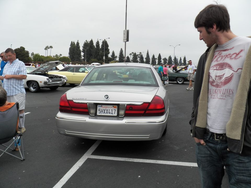 Rear of silver Mercury Grand Marquis with plate 5HXX417, man observing