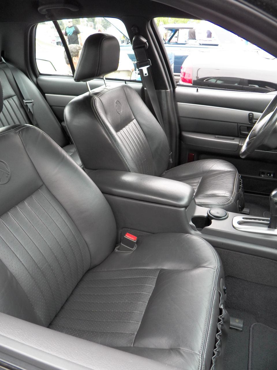 Black leather bucket seats and center console with shifter in sedan interior