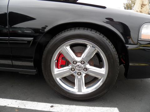 2003 Ford Crown Victoria - Close-up of a polished five-spoke wheel and red-painted brake caliper on a black sedan