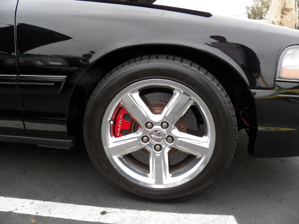 Chrome five-spoke wheel with red brake caliper on black Mercury Marauder