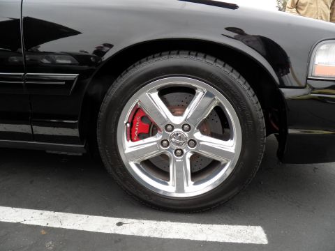 2003 Ford Crown Victoria - Detail of a black Mercury Marauder front wheel showing chrome five-spoke alloy and red brake caliper