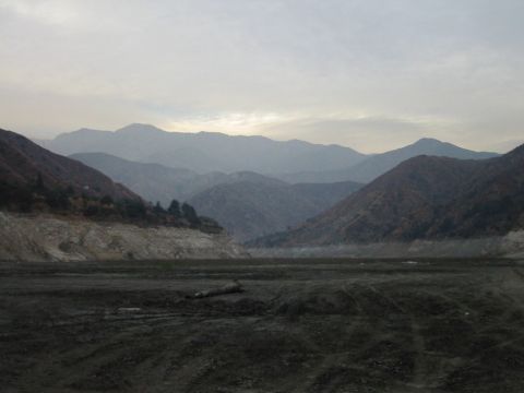 1985 Ford Bronco - A wide view of a valley surrounded by layered mountains under a cloudy sky.