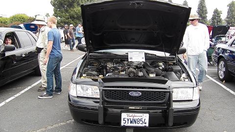 2003 Ford Crown Victoria - Front view of black Crown Vic, hood up, push bar reads Code 3, California plate 5YWN854