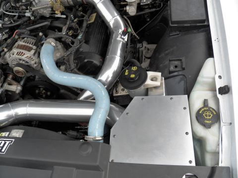 2003 Ford Crown Victoria - Close-up of chrome intake piping and blue coolant hose beside a washer-fluid-only reservoir
