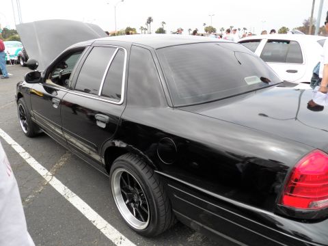 2003 Ford Crown Victoria - Lowered black Crown Victoria shown hood-up among other sedans in a car-show parking lot