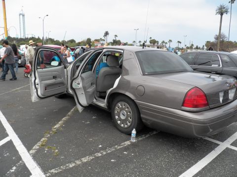 2003 Ford Crown Victoria - Beige Crown Victoria with doors open revealing cloth interior, water bottle on pavement