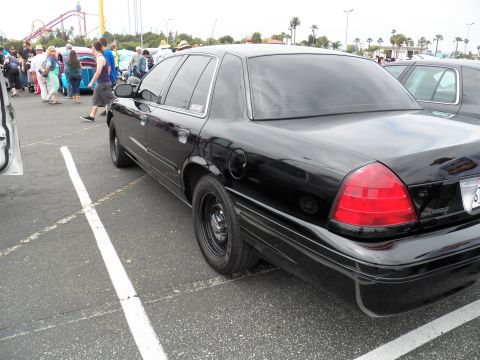 2003 Ford Crown Victoria - Black Crown Victoria parked at car show with roller coaster and tent crowd behind