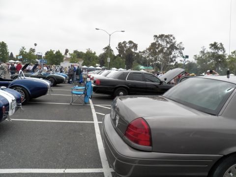 2003 Ford Crown Victoria - Gray Crown Victoria foreground with black sedan and blue Cobra roadster along the row