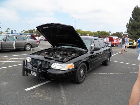 2003 Ford Crown Victoria - Black Crown Victoria with brush guard and spotlight displayed hood-up in parking lot