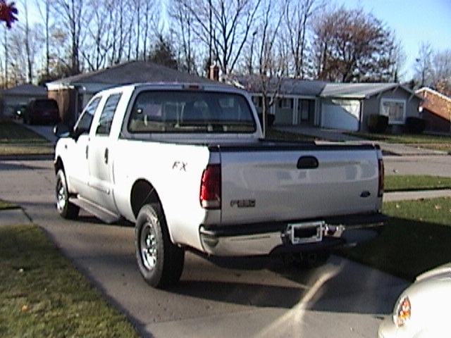 Silver Ford F-250 Super Duty SuperCab pickup, rear view in a suburban driveway