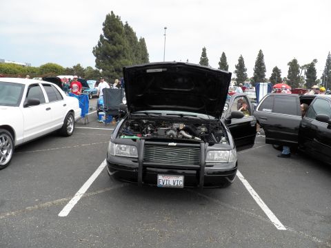2003 Ford Crown Victoria - Show sedan displayed open-hood, front-facing, in a parking lot with onlookers