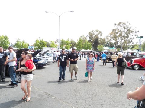 2003 Ford Crown Victoria - Attendees stroll past show vehicles including a vintage coupe on sunny asphalt