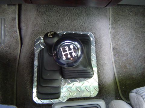 1989 Ford Ranger - Interior view of a diamond plate shift bezel and dual gear shifters.