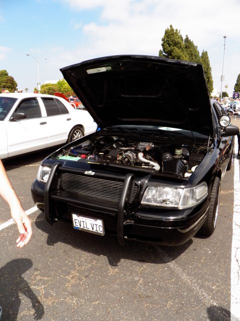 2003 Ford Crown Victoria - Front view of a black Ford sedan with grille guard and raised hood