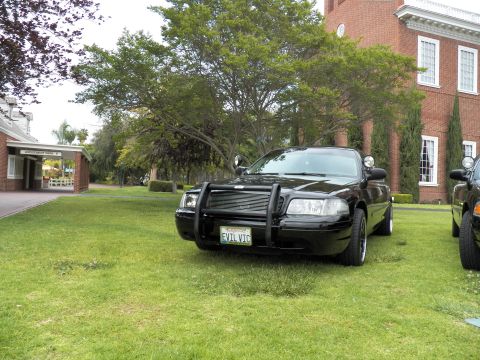 2003 Ford Crown Victoria - Front three-quarter view of a black Crown Victoria with grille guard, plate reading EVIL VTC