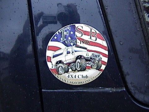 1995 Ford Bronco - Close-up of a round 'FSB 4X4 Club' decal applied to the dark blue rear quarter panel of a Ford Bronco, showing an illustrated white lifted…