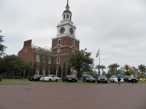 2003 Ford Crown Victoria - Wide view of a brick Independence Hall replica with sedans parked on the grass and palms beyond.