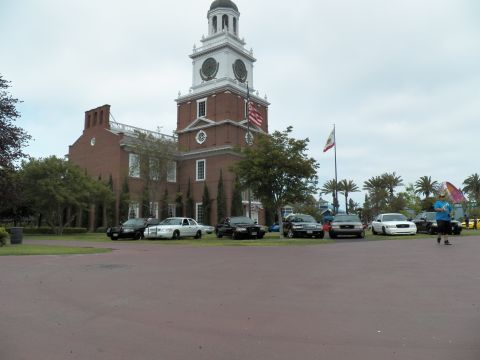2003 Ford Crown Victoria - Independence Hall replica fronted by black and white sedans on grass under an overcast sky.