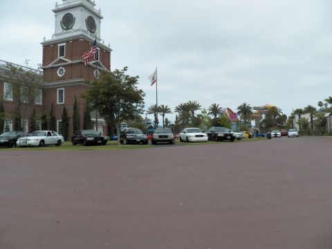 2003 Ford Crown Victoria - Row of black and white sedans on a lawn fronting a brick Independence Hall replica, maroon plaza foreground.