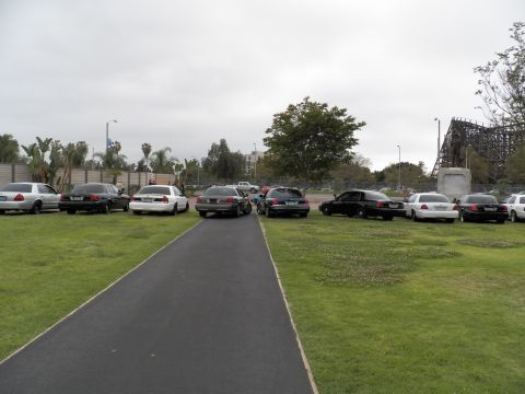 2003 Ford Crown Victoria - Crown Victoria sedans lined either side of a path, wooden coaster structure in the distance