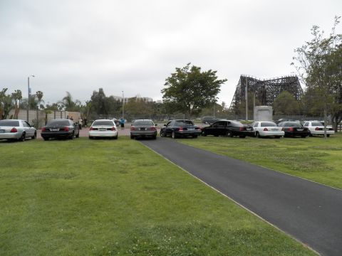 2003 Ford Crown Victoria - White, black and silver sedans parked along a lawn path, wooden coaster on the horizon