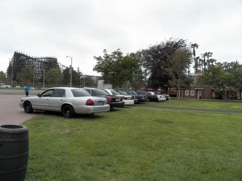 2003 Ford Crown Victoria - Silver Mercury sedan with black wheels heading a lineup near a wooden roller coaster