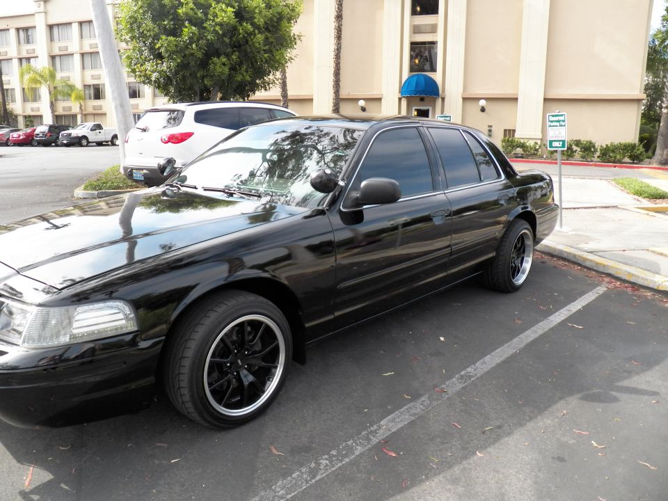 Black Ford Crown Victoria sedan side-front view in parking lot at hotel