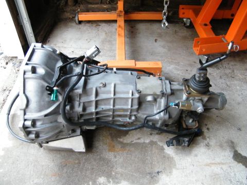 2004 Ford Crown Victoria - Automatic transmission assembly, likely from a Ford Crown Victoria, is shown on a garage floor.