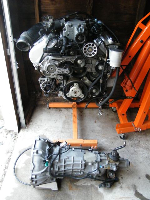 2004 Ford Crown Victoria - Engine and transmission assembly displayed on engine stands in a garage.