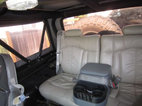 1974 Ford Bronco - Rear interior of a vehicle, leather seats and a spare tire.