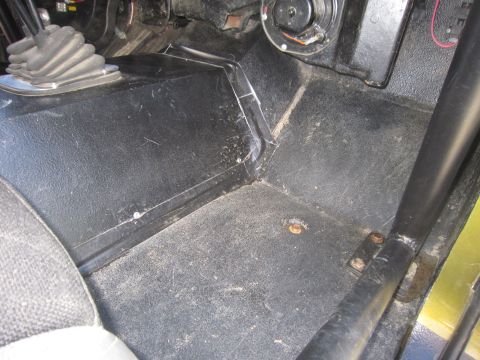 1974 Ford Bronco - Vehicle interior floor with transmission tunnel, seat, and roll bar visible.