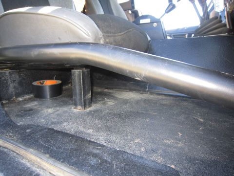 1974 Ford Bronco - A roll of black duct tape sits on the floor of a vehicle next to a roll bar support.