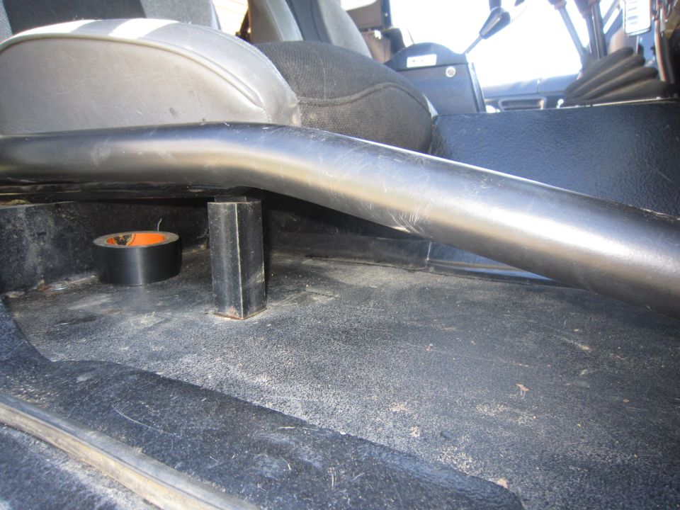 Roll bar support and roll of tape on the floor of a vehicle's interior