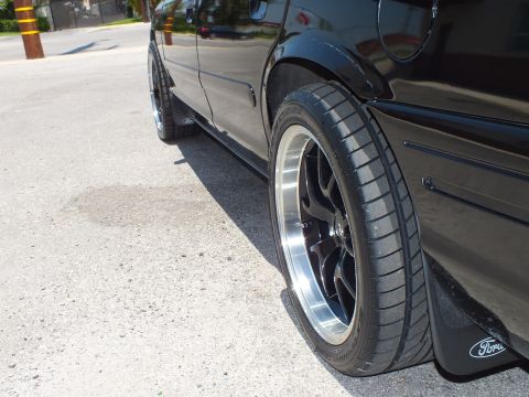 2003 Ford Crown Victoria - Detail of chrome-lip black rear wheel and Ford-logo mudflap on lowered Crown Vic.