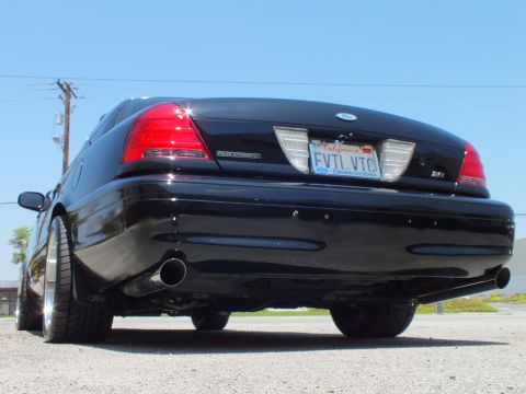 2003 Ford Crown Victoria - Tail of a black Ford sedan showing dual exhaust tips, SVT badge and California plate reading FVTL VTC.