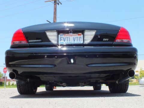 2003 Ford Crown Victoria - Straight-on rear shot of a black Ford sedan with dual exhaust, SVT badge and FVTL VTC license plate.