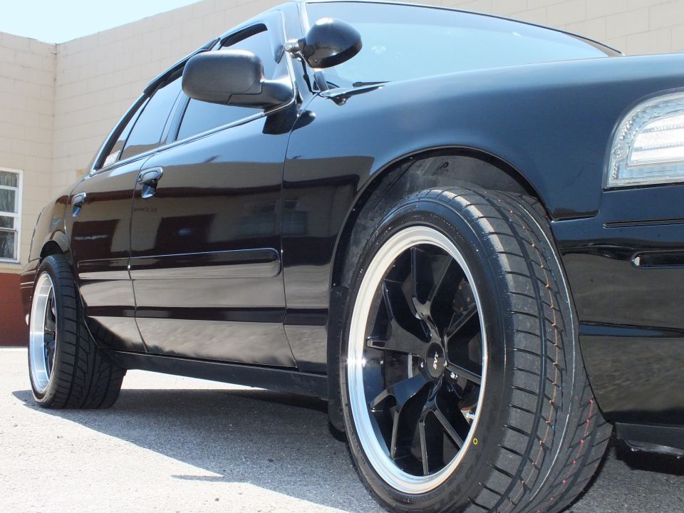Black Ford Crown Victoria front quarter with black polished-lip wheel and side mirror