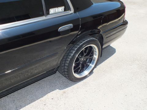 2003 Ford Crown Victoria - Rear quarter of a lowered black Ford sedan with an autotrader window decal and black polished-lip wheel.