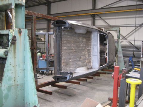 1973 Ford Ranchero - Vehicle body is inverted and supported by a metal frame in a workshop setting, suggesting a restoration or rebuild process.