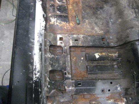 1973 Ford Ranchero - The interior floor pan shows significant rust and wear, indicating a need for extensive restoration.