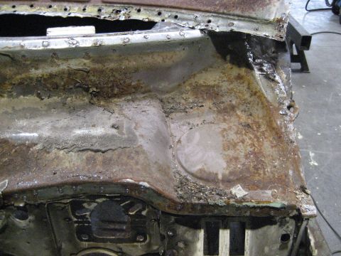 1973 Ford Ranchero - This severely rusted vehicle firewall shows extensive corrosion and damage, indicating a need for significant repair.