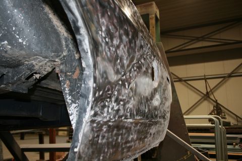 1973 Ford Ranchero - Close-up of a damaged car body panel undergoing repair work.