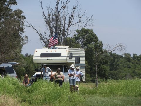 1968 Ford Mustang - People and an RV are gathered in a grassy field under a clear sky.