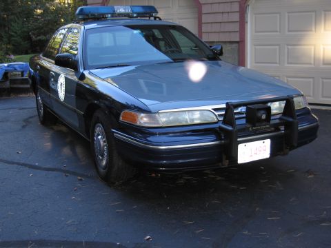 2001 Ford Crown Victoria - Front view of a dark blue 2001 Ford Crown Victoria police car parked in a driveway.