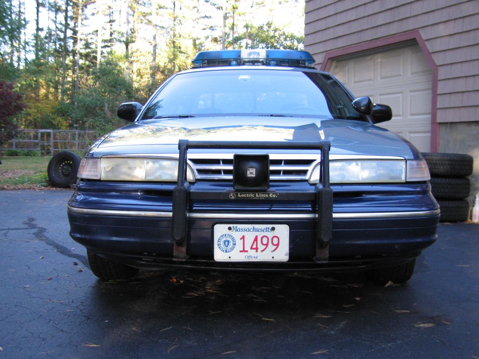 Blue police car front view with push bumper and light bar